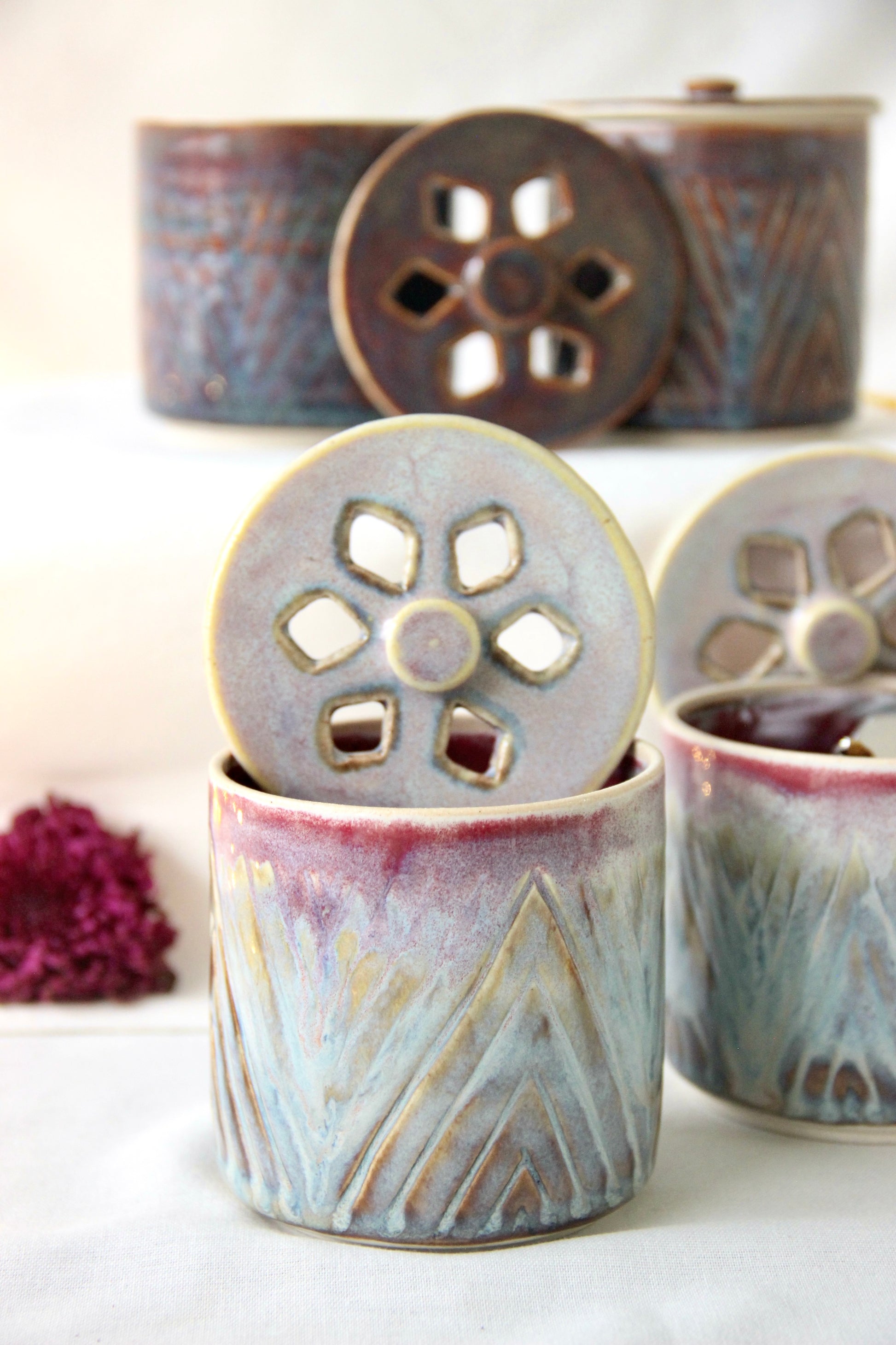 Ceramic containers with decorative lids on a white surface